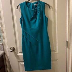 Professional dress with angled pleats on bodice and skirt. Sleeveless.
